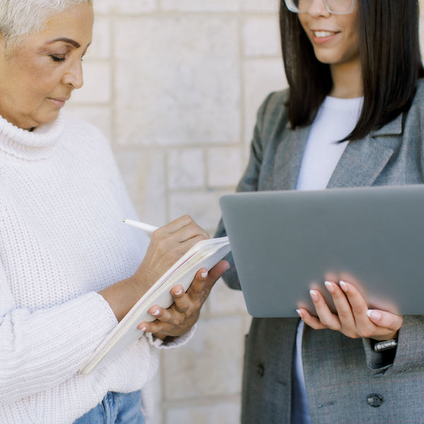 Two women collaborating—one taking notes, the other holding a laptop—symbolizing the care, expertise, and community behind our Pelvic Health Directory. We're here to connect you with trusted professionals who understand your journey.
